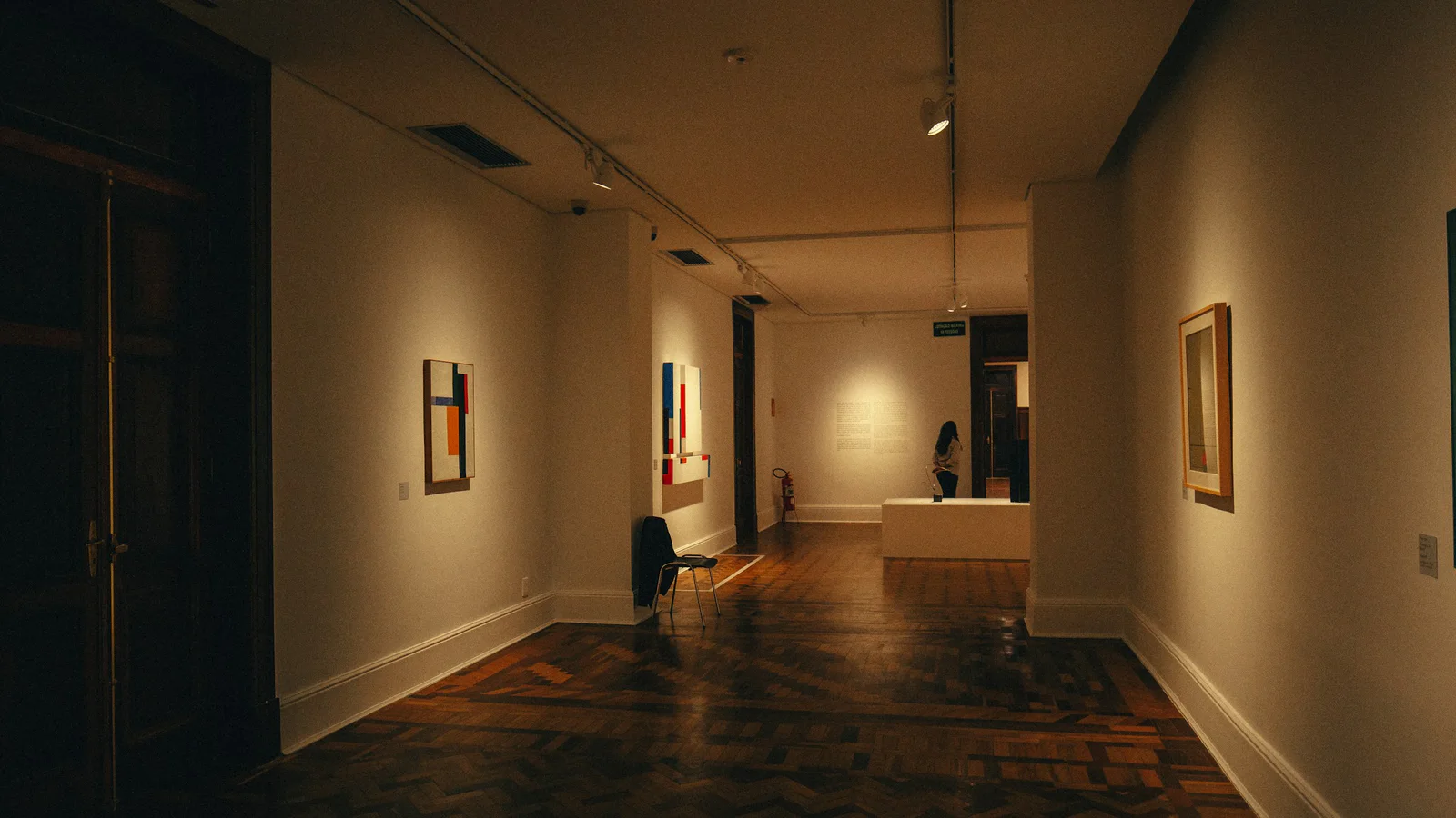 Real art-gallery hallway with framed paintings displayed on the walls